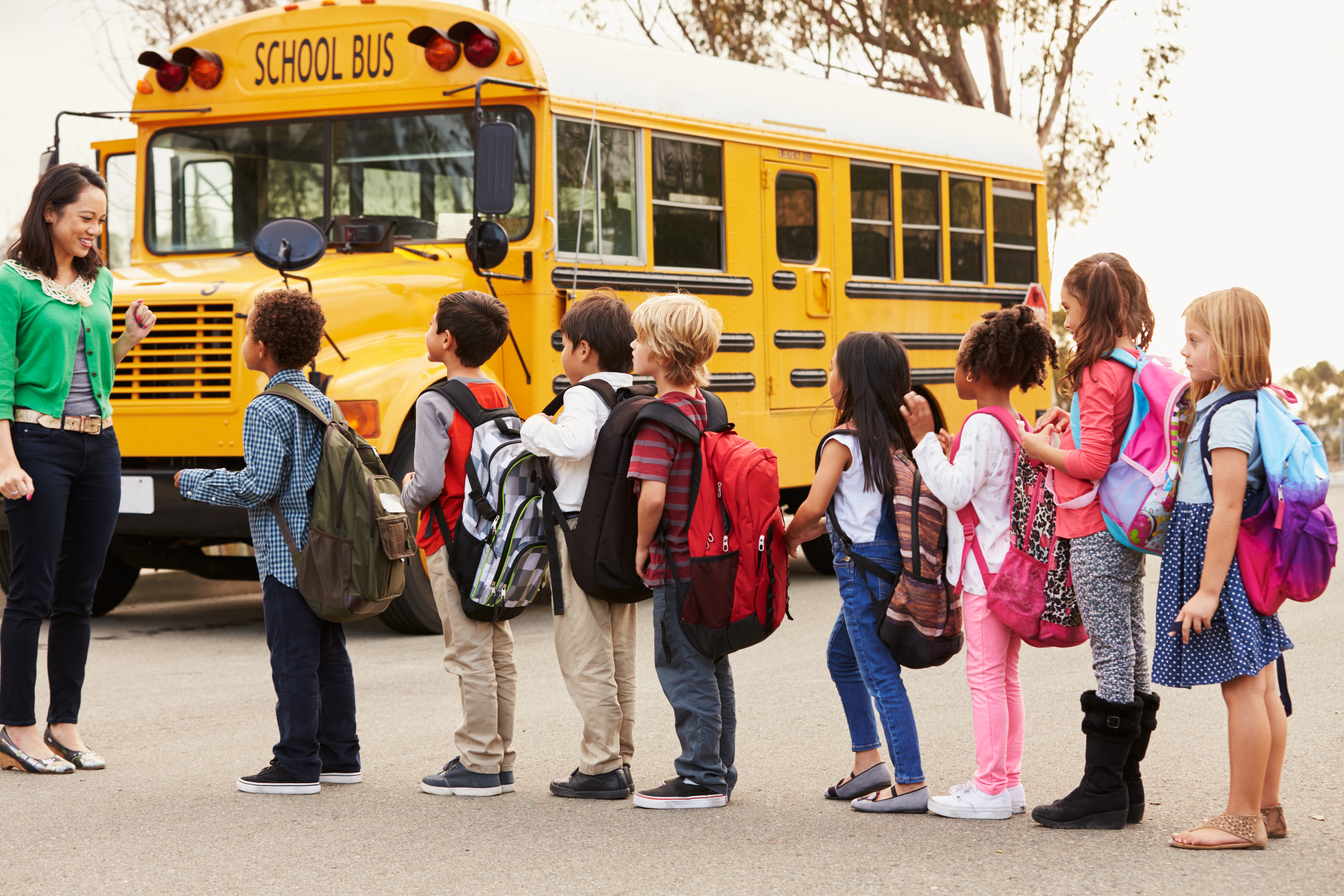teacher and student in line for the school bus